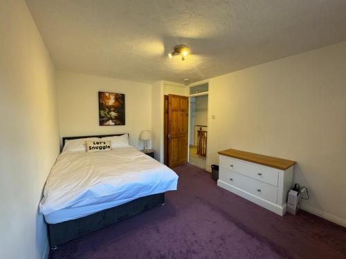 a bedroom with a bed and a dresser in it at IcandoWorld Reading House in Earley