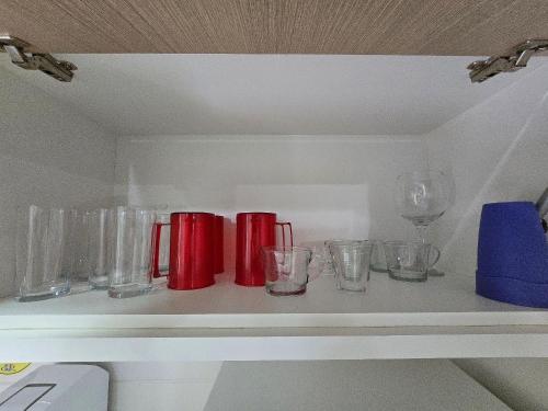 a shelf with glasses and wine glasses on it at Apartamentos em Rio Quente com maravilhosa área de lazer e excelente localização in Rio Quente
