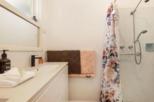 a bathroom with a shower curtain and a sink at Shelby Cottage in Paynesville