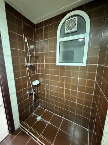 a bathroom with a shower with a window at International Abu-Dhabi Hostel Villa in Abu Dhabi