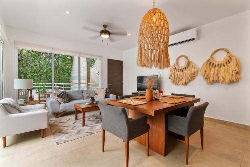 a living room with a wooden table and chairs at Encanto Private Balcony 2 Pools Gym Only 5 Minutes To Tulum Beaches in Tulum