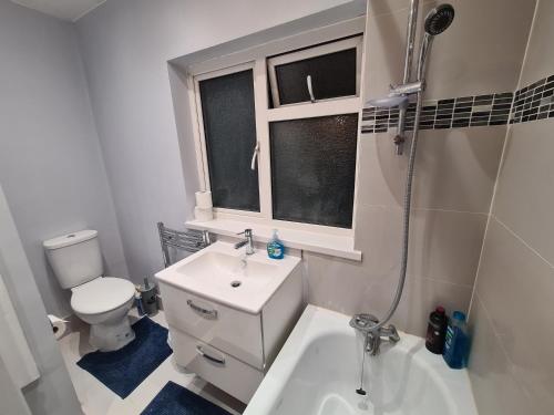 a bathroom with a sink and a toilet and a shower at Cheerful 4/5 bed house - Heathrow in West Drayton