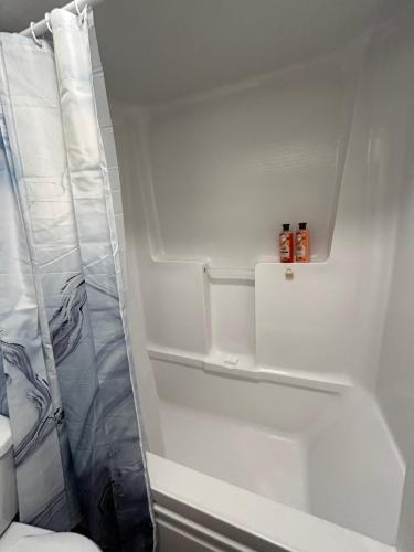 a white bathroom with a shower and a sink at Smokehouse Suites and Stay in Guelph