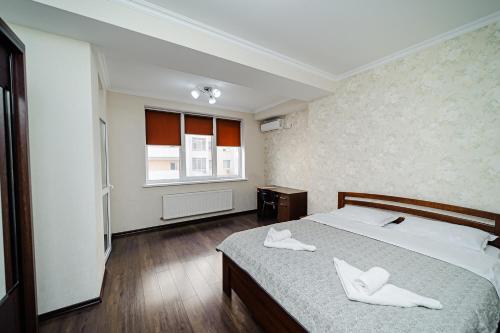 a bedroom with a bed with two white towels on it at Two - bedroom Nicole Testimitanu in Chişinău