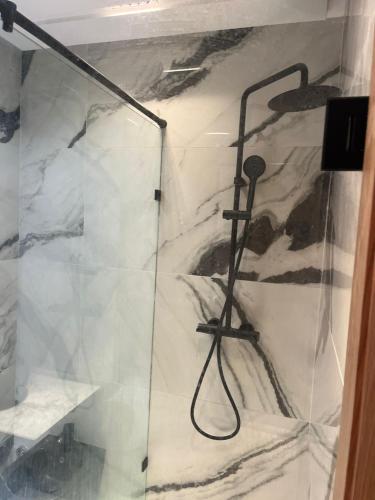a bathroom with a shower with a glass door at downtown luxurious flat quartier Gauthier in Casablanca
