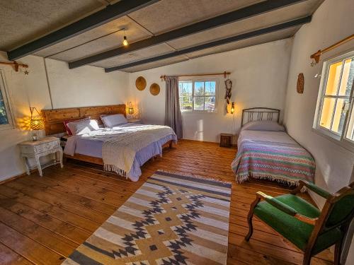 ein Schlafzimmer mit zwei Betten und einem Stuhl in der Unterkunft Casa Campo 1931 in Colonia del Sacramento
