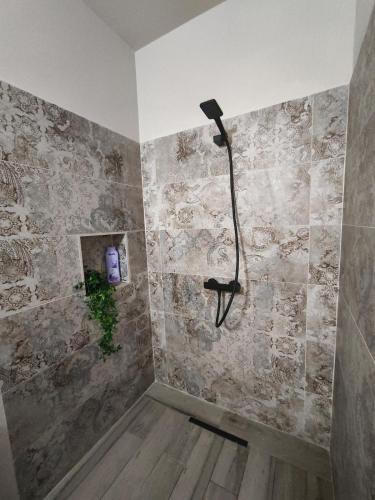 a bathroom with a shower with a stone wall at Home Glos ter in Tarajalejo