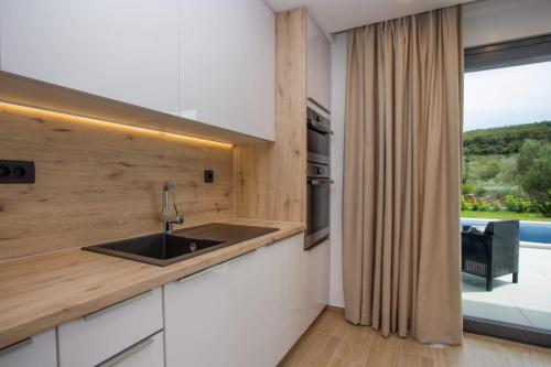 a kitchen with a sink and a window with a view at Villa Tesa 2 in Okrug Donji