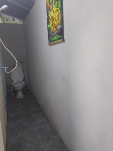 a bathroom with a toilet and a picture on the wall at Mateoasis in Ko Kood