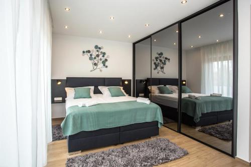a bedroom with two beds and a large mirror at Villa Tesa 2 in Okrug Donji