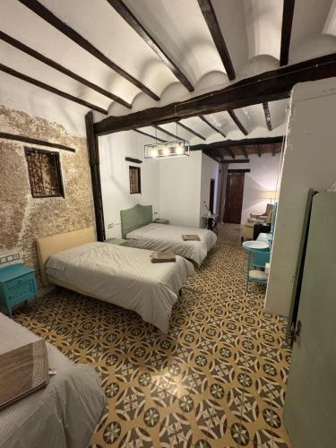 a row of beds in a room with a wall at La Replaceta in Segorbe