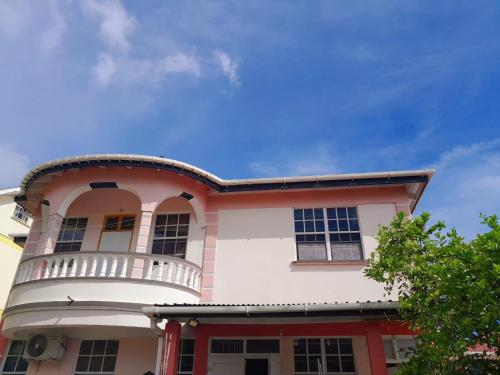 a large building with a balcony on top of it at Stephen Guest House in Mahaut