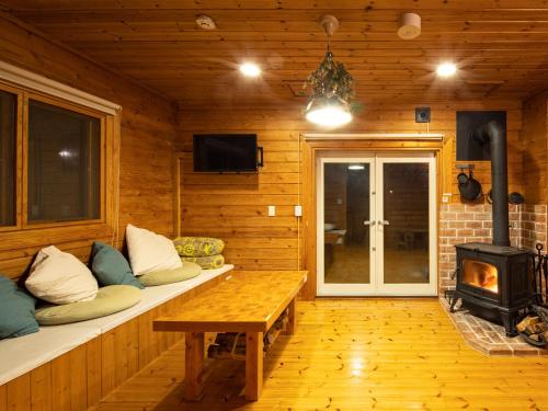 a living room with a fireplace in a log cabin at ALL SEASON RESORT No3 Kino Nukumori in Jōnouchi