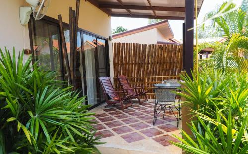a patio with two chairs and a table at Escape-Cabins in Ko Lanta