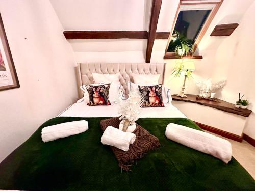 une chambre avec un grand lit avec une couverture verte et des oreillers dans l'établissement Luxury 4 bed former hay loft SLEEPS 6, à Usk
