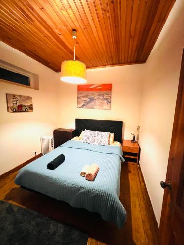 a bedroom with a blue bed with a wooden ceiling at Lisbon Alcantara LX in Lisbon