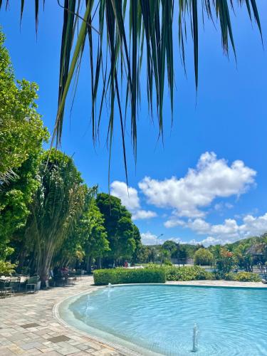 a swimming pool in a park with trees at Apartamento no Iloa Residence - Com Enxoval Completo in Barra de São Miguel