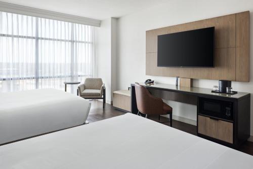 a hotel room with a bed and a desk with a television at Marriott Bloomington Normal Hotel and Conference Center in Bloomington