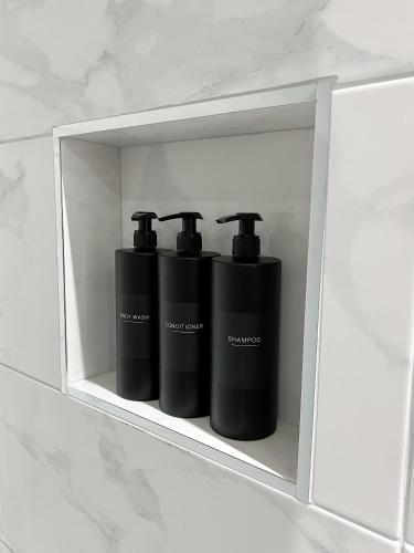 a shelf with two black containers on it at Stylish 2 Bedroom Flat City Centre - Free Parking in Cardiff