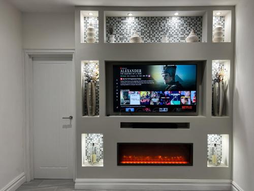 a tv in a wall with a fire place at Stylish 2 Bedroom Flat City Centre - Free Parking in Cardiff