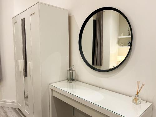 a bathroom with a mirror and a white sink at Stylish 2 Bedroom Flat City Centre - Free Parking in Cardiff