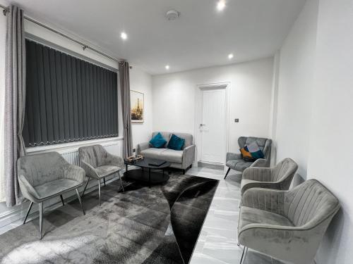 a living room with couches and chairs and a window at Stylish 2 Bedroom Flat City Centre - Free Parking in Cardiff