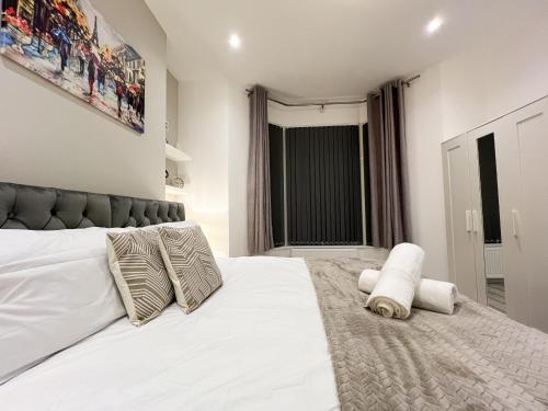 a bedroom with a large white bed with pillows at Stylish 2 Bedroom Flat City Centre - Free Parking in Cardiff