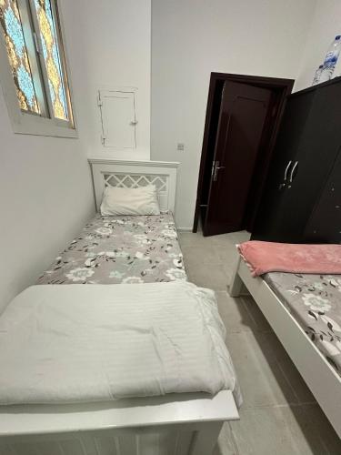 a small bedroom with a bed and a window at International Abu-Dhabi Hostel Villa in Abu Dhabi