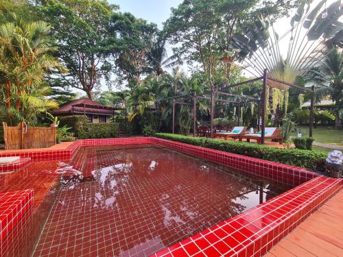 a bird cage with ducks in a pond at Red Moon Hideaway in Ko Chang