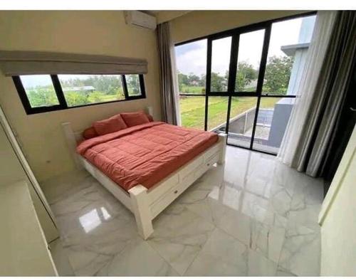 a bedroom with a bed with a large window at Villa Mike Yogyakarta in Gandok