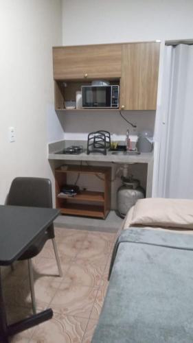 a small room with a desk and a microwave at Residencial JC II sua casa em Belém do Pará in Belém