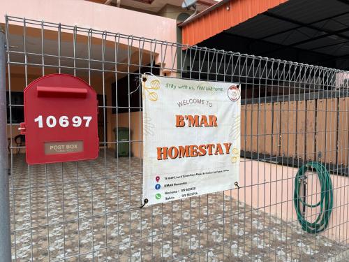 a cage with a sign in front of a building at B'Mar Homestay in Tawau
