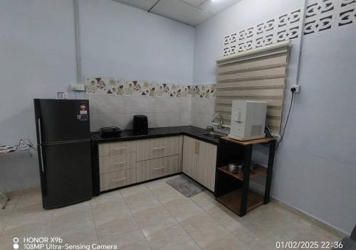 cocina con nevera negra en una habitación en Homestay Zainab Sg Dua Mslim With 100mbps Wifi, en Kepala Batas