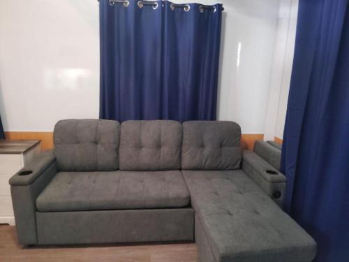 a couch in a living room with blue curtains at Old Wooden Bridge Resort & Marina in Big Pine Key
