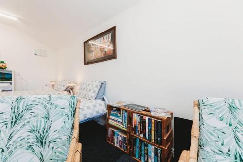 a living room with two beds and a book shelf at Lovely Pet Friendly Townhouse in Methven