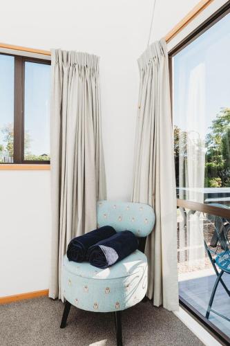 a blue chair in a room with a window at Lovely Pet Friendly Townhouse in Methven