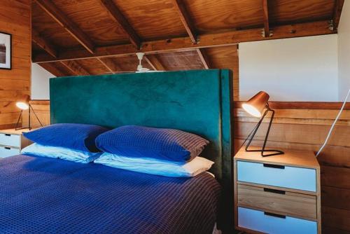 a bedroom with a blue bed with a green headboard at Lovely Pet Friendly Townhouse in Methven