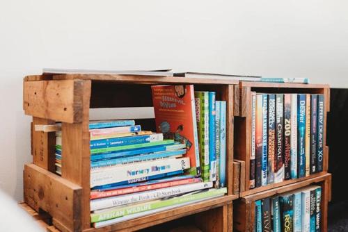 a wooden book shelf filled with lots of books at Lovely Pet Friendly Townhouse in Methven