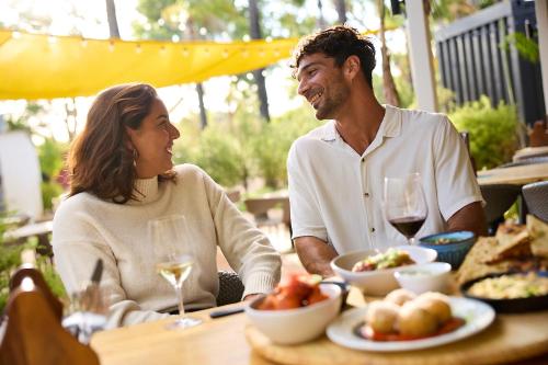a man and a woman sitting at a table with food at The Swan Valley Hotel in Henley Brook