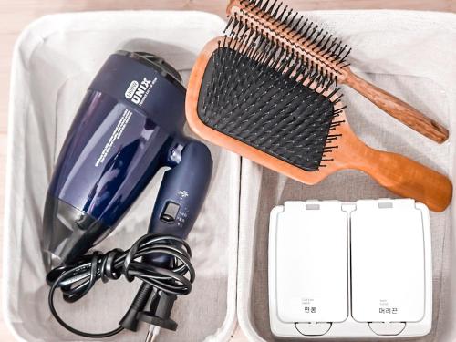 a plastic container with a hair dryer and a hairbrush at Stay Toseong in Busan