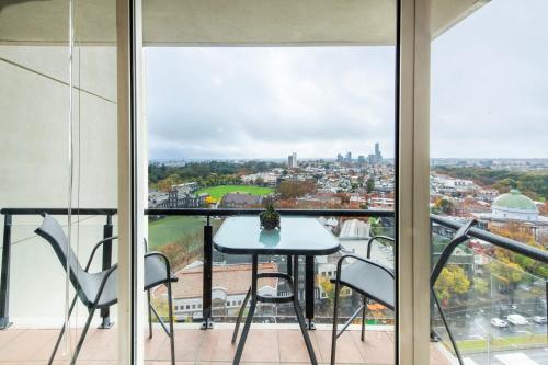 a balcony with a table and chairs and a view at Stylish Cosy Gem w Pool, Tennis Court, & Parking in Melbourne