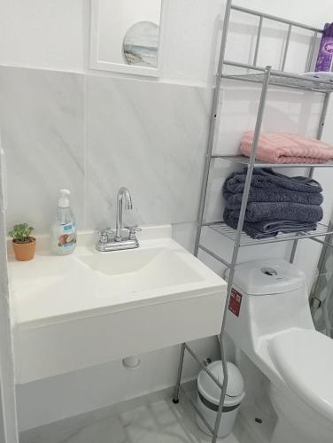 a white bathroom with a sink and a toilet at FW Peninsula Rental in Puerto Vallarta