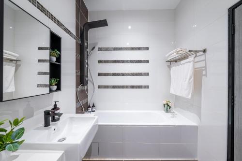a white bathroom with a tub and a sink at La Ferringhi Villa - Tropical Collection, by ALV in Batu Ferringhi