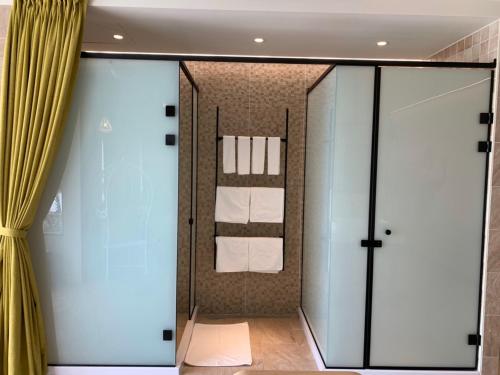a bathroom with a glass door with towels in it at Beachcastle & Sea View Villa in Magong
