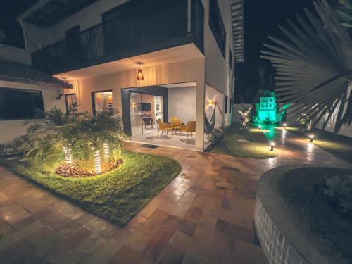 a house with lights in the yard at night at Mar e Lar in Maragogi