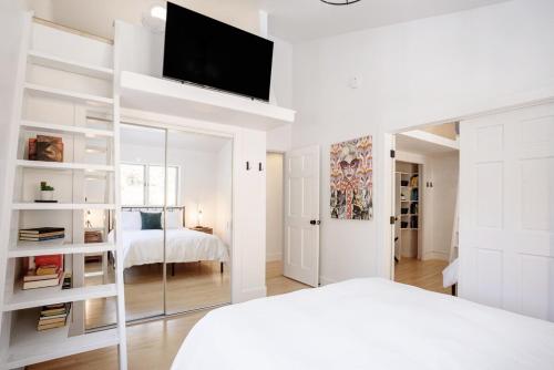 a white bedroom with a bed and a mirror at Boulder Luxury Getaway 7 acres River & Pond in Boulder