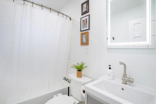 a white bathroom with a toilet and a sink at Boulder Luxury Getaway 7 acres River & Pond in Boulder