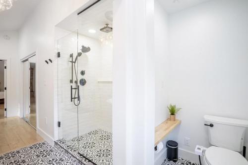 a white bathroom with a shower and a toilet at Boulder Luxury Getaway 7 acres River & Pond in Boulder