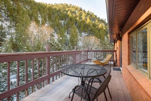 a patio with a table and chairs on a balcony at Boulder Luxury Getaway 7 acres River & Pond in Boulder