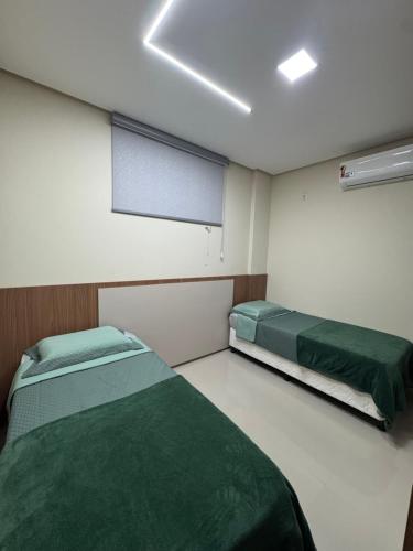 a hospital room with two beds and a window at Flat Novo Todo Climatizado em Alter do Chão in Alter do Chao